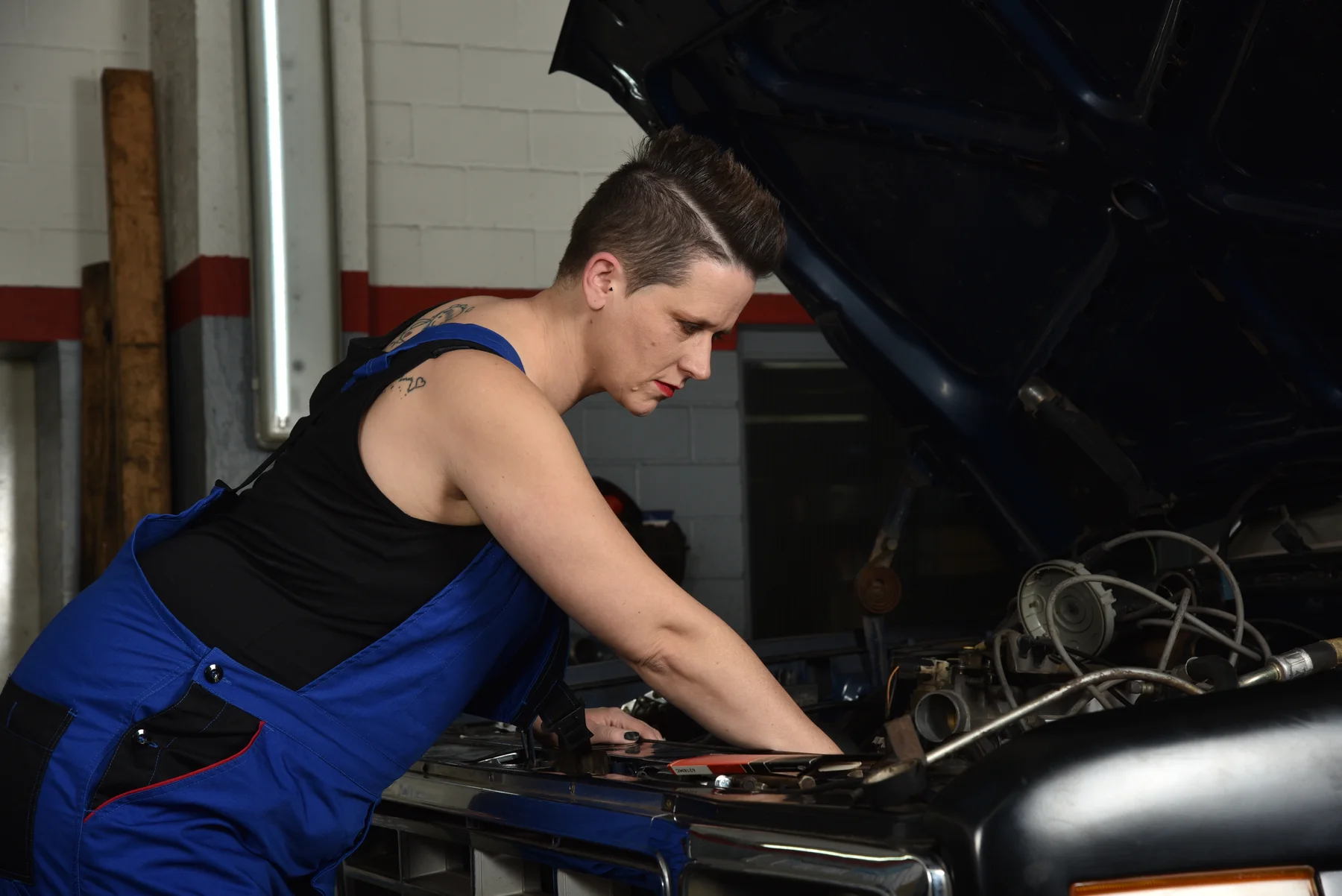 Unternehmerin bei der Arbeit an einem Fahrzeug in ihrer Werkstatt