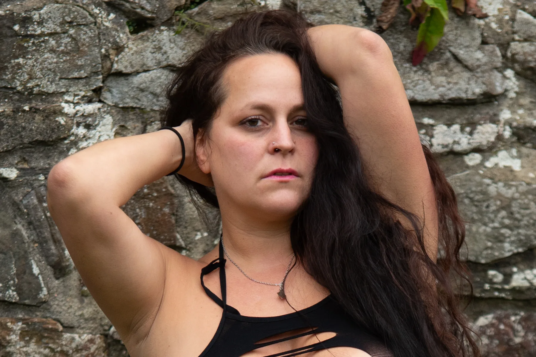 Ausdrucksstarkes Portrait einer Frau vor einer Steinmauer an der Burg Windeck
